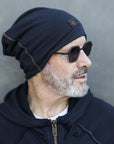 A man modeling the One Golden Thread OG Cloud Beanie in Charcoal Blue