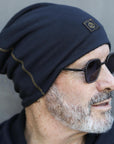 A man modeling the One Golden Thread OG Cloud Beanie in Charcoal Blue