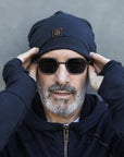 A man modeling the One Golden Thread OG Cloud Beanie in Charcoal Blue
