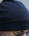 A man modeling the One Golden Thread OG Cloud Beanie in Charcoal Blue
