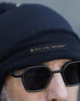 A man modeling the One Golden Thread OG Cloud Beanie in Charcoal Blue