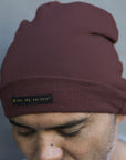 A man modeling the One Golden Thread OG Cloud Beanie in Eggplant