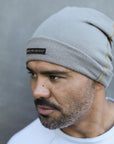 A man modeling the One Golden Thread OG Cloud Beanie in Shroom