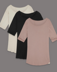 Flat lay of three crew neck shirts in different colors