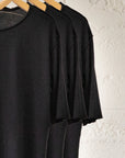 Black crew neck three pack on wooden clothing racks