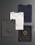 three folded shirts in different colors on a dark gray background