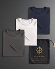 three folded shirts in different colors on a dark gray background