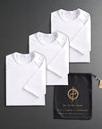 three folded white shirts on a dark gray background