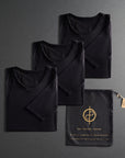 three folded shirts in black on a dark gray background
