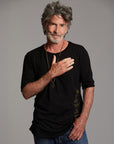Man modeling a crew neck t shirt with gold graphics
