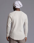 A man modeling a One Golden Thread Waffle Long Sleeve Raglan shirt in white stone