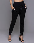 A woman modeling the One Golden Thread Jogga Pants in Black