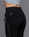 A woman modeling the One Golden Thread Jogga Pants in Black