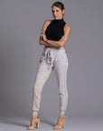 A woman modeling the One Golden Thread Jogga Pants in White Stone