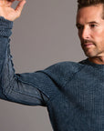 A man modeling a One Golden Thread Waffle Long Sleeve Raglan shirt in blue mineral