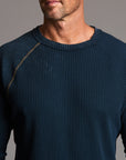 A man modeling a One Golden Thread Waffle Long Sleeve Raglan shirt in blue mineral