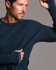 A man modeling a One Golden Thread Waffle Long Sleeve Raglan shirt in blue mineral