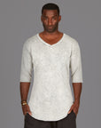 A man modeling in a grey mineral sweater v neck shirt