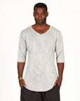A man modeling in a grey mineral sweater v neck shirt