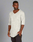 A man modeling in a grey mineral sweater v neck shirt