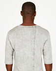 A man modeling in a grey mineral sweater v neck shirt