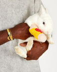A man wearing the One Golden Thread Fleece Sweater v neck shirt in grey mineral color while holding a bunny