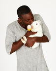 A man wearing the One Golden Thread Fleece Sweater v neck shirt in grey mineral color while holding a bunny