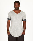 A man modeling in a grey mineral sweater v neck shirt