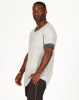 A man modeling in a grey mineral sweater v neck shirt