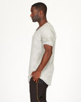 A man modeling in a grey mineral sweater v neck shirt