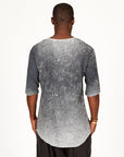 A man modeling in a grey mineral sweater v neck shirt