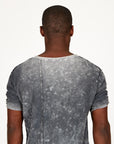 A man modeling in a grey mineral sweater v neck shirt