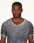 A man modeling in a grey mineral sweater v neck shirt