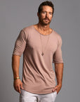 Male modeling light pink crew neck shirt