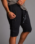 A man modeling charcoal blue milanos mid shorts