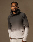 a male modeling the pullover plush hoodie in a grey gradient