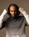 a male modeling the pullover plush hoodie in a grey gradient