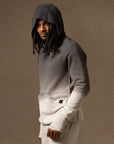a male modeling the pullover plush hoodie in a grey gradient