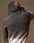 a male modeling the pullover plush hoodie in a grey gradient