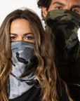 A man and woman wearing the One Golden Thread Versawrap as facial coverings in reversible Camo colors