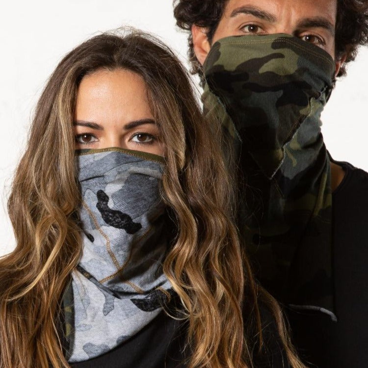 A man and woman wearing the One Golden Thread Versawrap as facial coverings in reversible Camo colors
