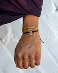 A person wearing a Customized MyIntent Gold Plated Black Twist Bracelet with the words "Inner Peace"