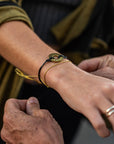 A person gifting a Customized MyIntent Black Twist Bracelet with the word "Grateful"