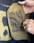 A man opening the pocket in the Minotaur Nature Wrap