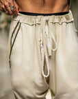 A man wearing the One Golden Thread Tree Pant in Ceremony Sand color