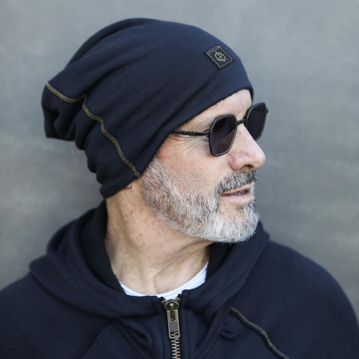 A man modeling the One Golden Thread OG Cloud Beanie in Charcoal Blue