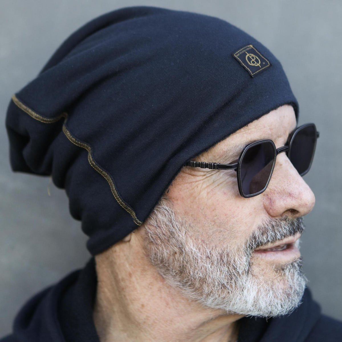 A man modeling the One Golden Thread OG Cloud Beanie in Charcoal Blue