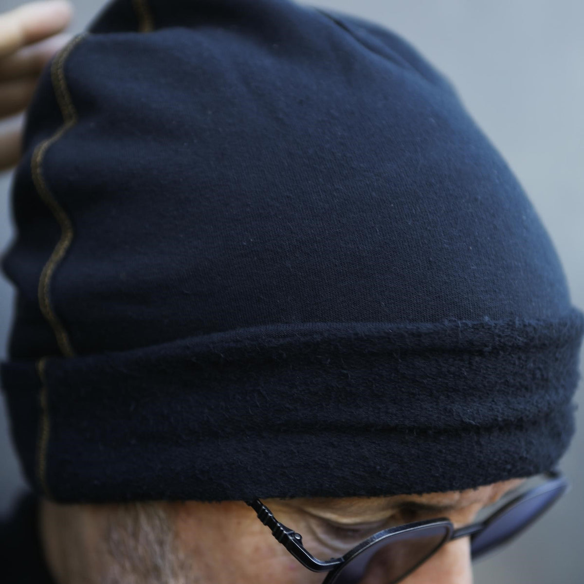A man modeling the One Golden Thread OG Cloud Beanie in Charcoal Blue