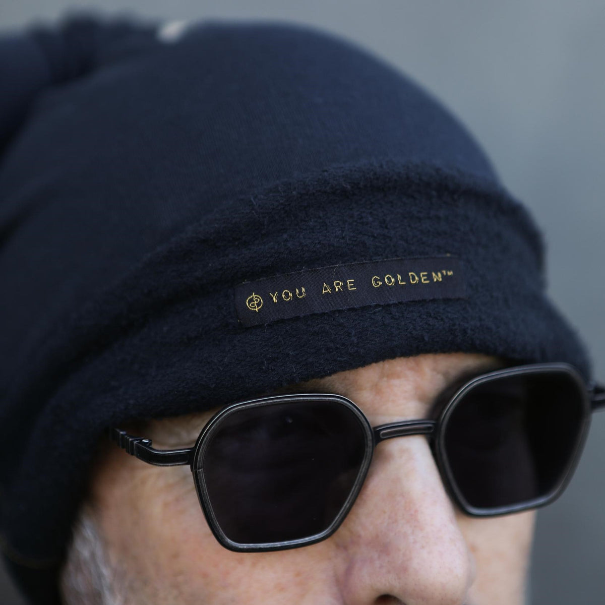A man modeling the One Golden Thread OG Cloud Beanie in Charcoal Blue