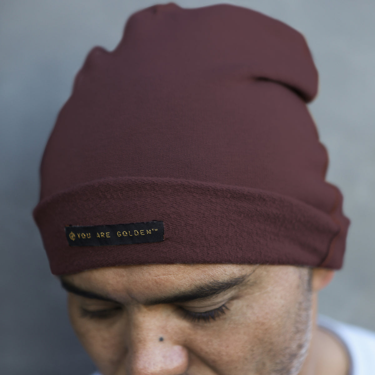 A man modeling the One Golden Thread OG Cloud Beanie in Eggplant